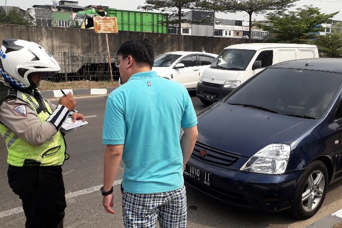 Seorang pengendara mobil Honda Odyssey terkena razia gabungan pengesahan Surat Tanda Nomor Kendaraan, di pintu tol Cengkareng Barat, Jakarta Barat pada Rabu (25/7/2018).