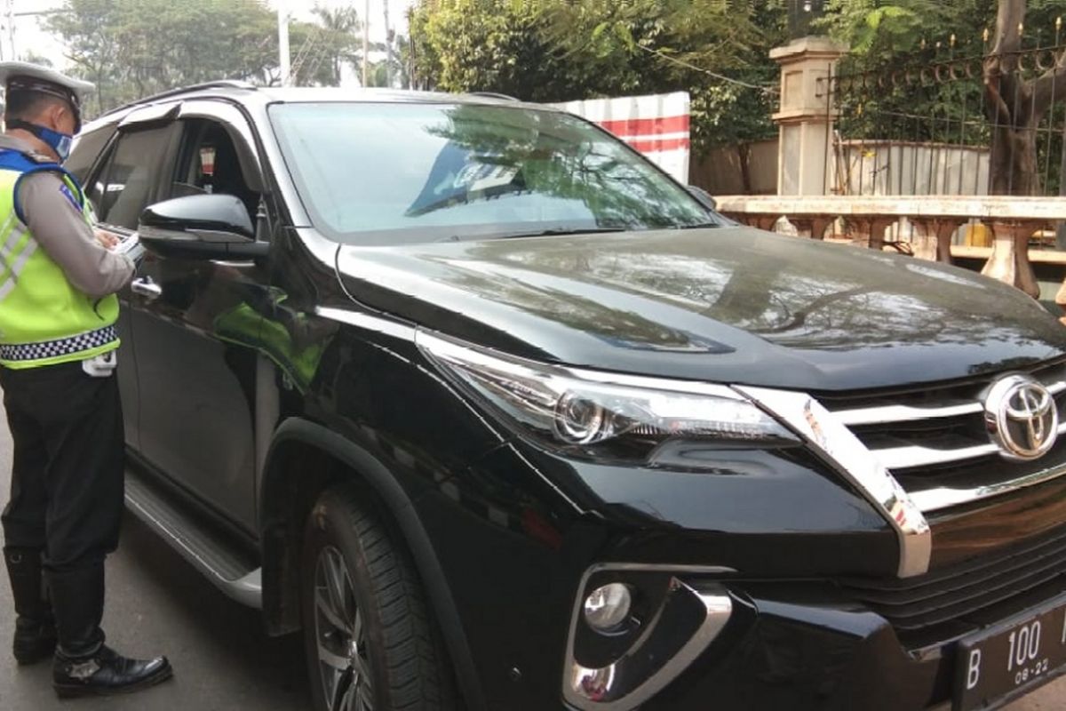 Polisi memberhentikan sebuah mobil bermerek Toyota Fortuner berwarna hitam dengan pelat nomor B 100 NAR di ruas Jalan MT Haryono ke arah Jalan Gatot Subroto,  Rabu (1/8/2018).