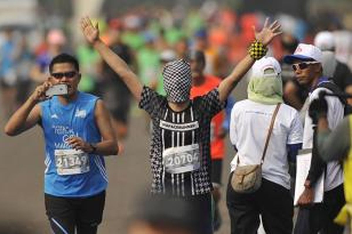 Ekspresi dan gaya peserta Mandiri Jakarta Marathon 2015 saat memasuki garis finis di Silang Monas Barat Daya, Jakarta, Minggu (25/10/2015).