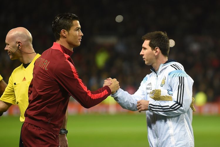 Striker Argentina Lionel Messi (kanan) berjabat tangan dengan striker Portugal Cristiano Ronaldo (kiri) menjelang pertandingan persahabatan internasional antara Argentina dan Portugal di Old Trafford di Manchester pada 18 November 2014. Lionel Messi dan Cristiano Ronaldo berpeluang bertemu di final Piala Dunia 2022 Qatar.