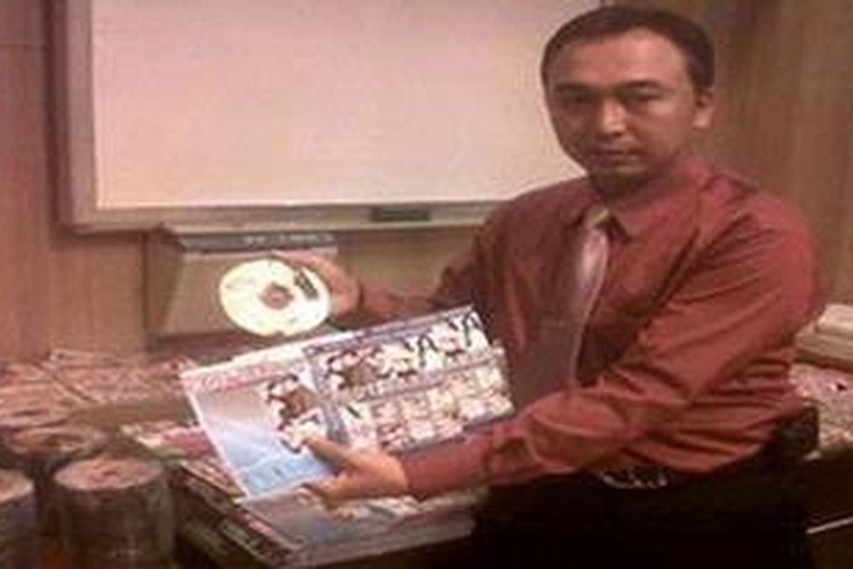 Ilustrasi: Petugas memperlihatkan VCD bajakan.