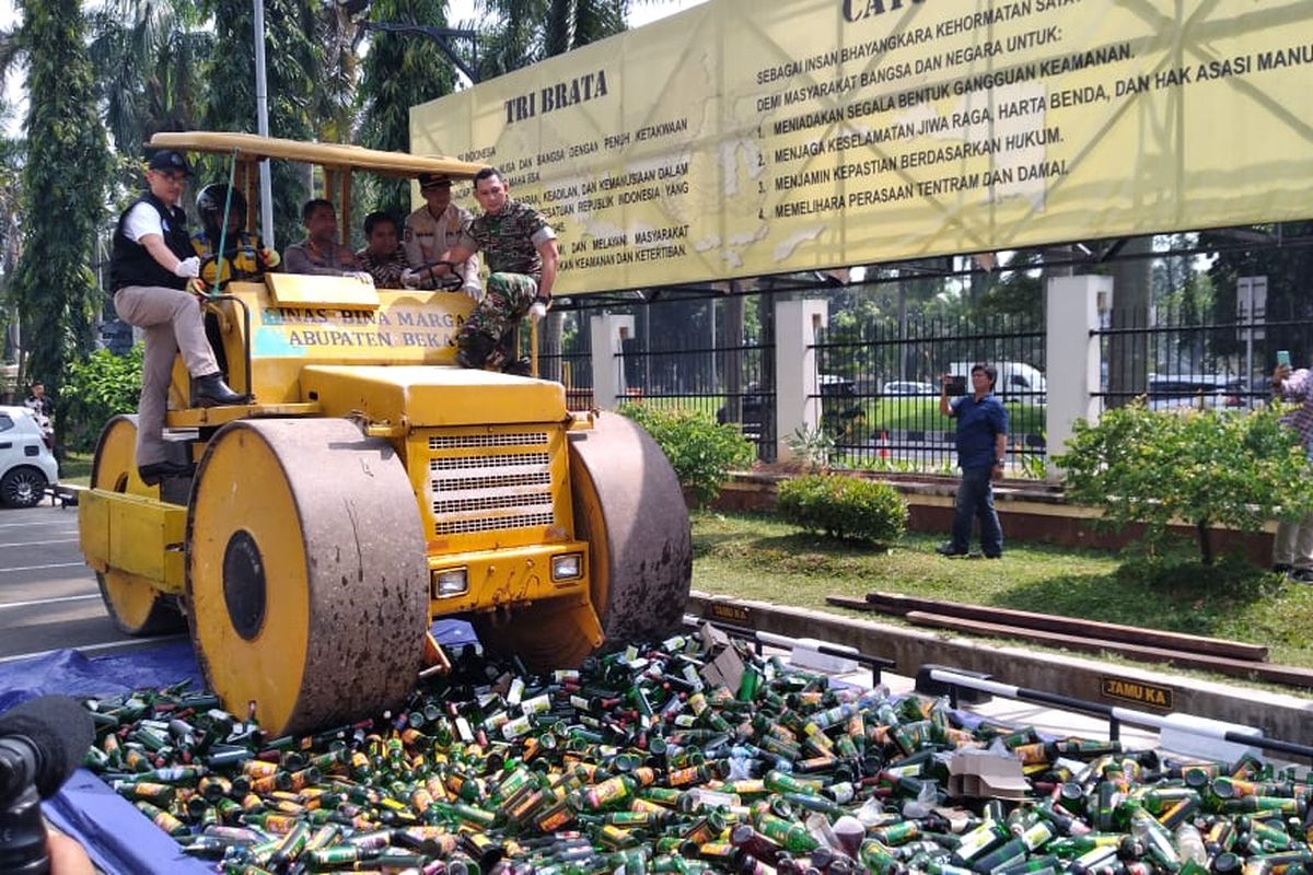 Proses pemusnahan ribuan botol minuman keras yang dilakukan di halaman Mapolres Bekasi pada Jumat (14/4/2023).