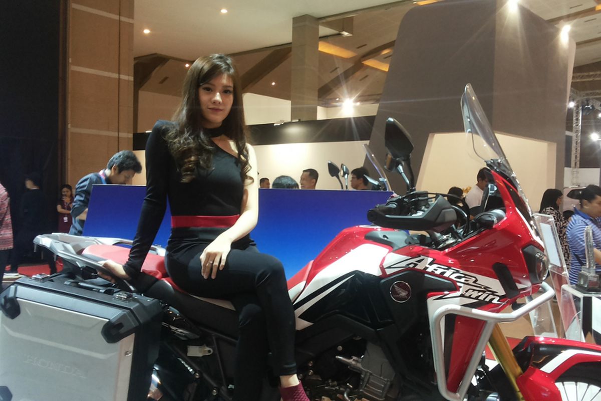 Salah soorang sales promotion girl (SPG) berpose di salah satu produk CRF yang dipajang di stan yang dibuka Honda selama Indonesia International Motor Show (IIMS), JIExpo, Kemayoran, Jakarta.