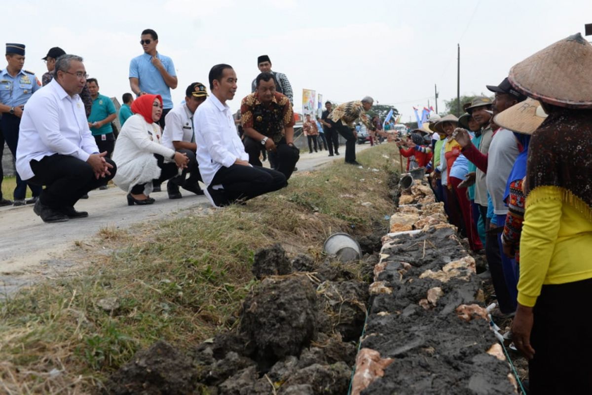 Presiden Joko Widodo (Jokowi) didampingi Menteri Desa, Pembangunan Daerah Tertinggal, dan Transmigrasi (Mendes PDTT) Eko Putro Sandjojo meninjau program Padat Karya Tunai (PKT) pembangunan talud jalan di Desa Tambirejo, Kecamatan Toroh, Kabupaten Grobogan, Jawa Tengah, Sabtu (15/9/2018)