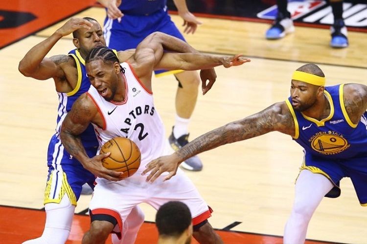 Kawhi Leonard (putih) dari Toronto Raptors dijaga oleh Andre Iguodala dan DeMarcus Cousins dari Golden State Warriors pada gim kelima final NBA 2019 di Scotiabank Arena pada 10 Juni, 2019, di Toronto, Kanada.