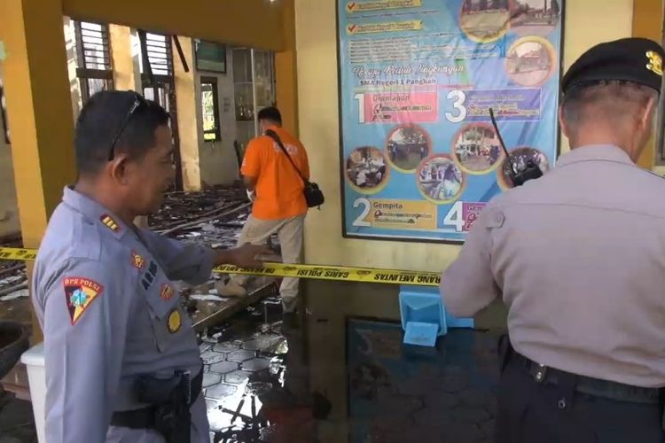 Petugas memasang garis polisi melakukan olah kejadian mencari oenyebab kebakaran gedung SMA 1 Pangkah, Kabupaten Tegal, Jawa Tengah, Kamis (27/2/2020)