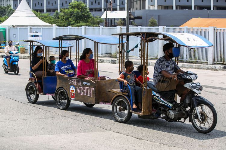 Orang tua bersama anak-anaknya saat menaiki motor saat melewati kawasan Kemayoran, Jakarta Utara, Rabu (16/9/2020). PSBB kembali diterapkan tanggal 14 September 2020, berbagai aktivitas kembali dibatasi yakni aktivitas perkantoran, usaha, transportasi, hingga fasilitas umum.