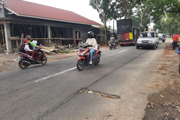 Kondisi Jalan Godean dari perempatan Pasar Godean ke arah barat. Jalan di sisi utara terlihat bergelombang dan beberapa terdapat lubang.