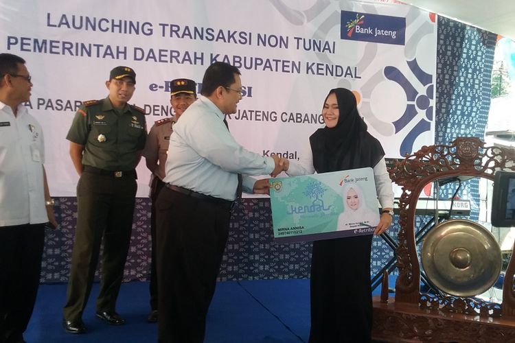 Bupati Kendal Mirna Anissa, secara simbolis menerima kartu e-retribusi dari kepala bank Jateng cabang Kendal. Kompas.Com/Slamet Priyatin