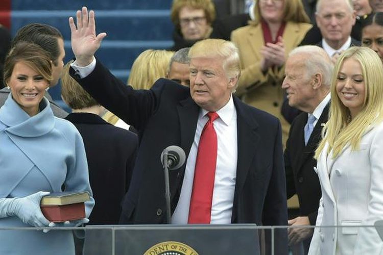 Presiden terpilih AS Donald Trump melambaikan tangan kepada warga dalam upacara pelantikan di Capitol AS, Washington DC, Jumat (20/1/2017). Prosesi pelantikan Trump dan Mike Pence selaku presiden dan wakil presiden terpilih AS berlangsung panjang. Serangkaian acara digelar mulai 19-21 Januari.