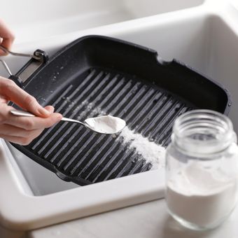 Ilustrasi membersihkan peralatan dapur berwarna hitam menggunakan baking soda