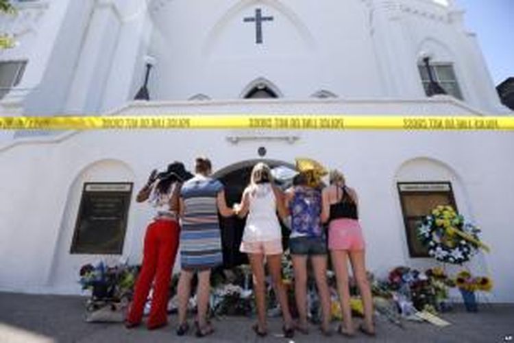 Warga berdoa di tempat memorial di depan Gereja Emanuel AME Church (18/6) di Charleston, South Carolina.