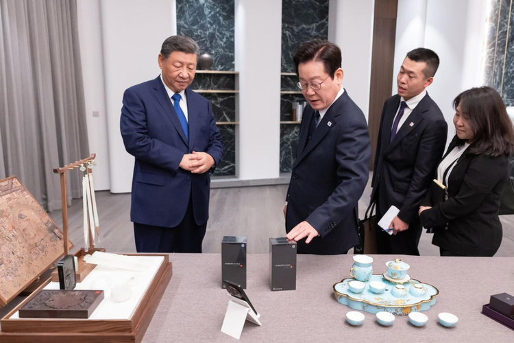 Presiden Korea Selatan (ketiga dari kanan) memegang boks HP Xiaomi 15 Ultra, hadiah pemberian Presiden China Xi Jinping saat keduanya mengadakan pertemuan bilateral, usai menghadiri Konferensi Tingkat Tinggi (KTT) Kerja Sama Ekonomi Asia-Pasifik (APEC) yang digelar di kota Gyeongju, Korea Selatan, Sabtu (1/11/2025). Di sebelah boks, tampak satu set hadiah dari Presiden Lee untuk Peng Liyuan, istri Xi Jinping, berupa teko bertangkai perak, lengkap dengan cangkir perak yang bermotif senada.