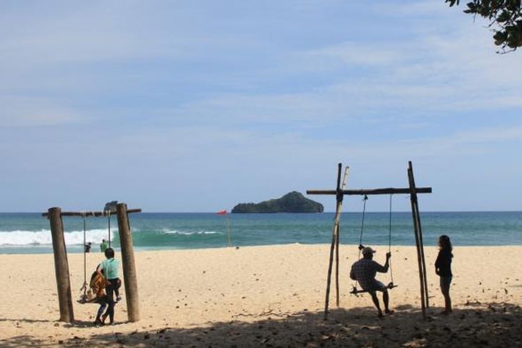 Sejumlah wisatawan saat bermain ayunan di Pantai Sendiki, Kabupaten Malang, Jawa Timur, Minggu (8/1/2017).