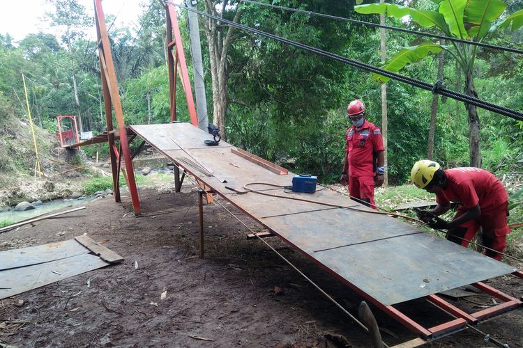 Anggota Vertical Rescue Indonesia (VRI) regional Lampung mengerjakan jembatan gantung di atas Sungai Kuripan, Bandar Lampung, Rabu (30/12/2020). Pembuatan jembatan ini untuk memudahkan akses pendidikan siswa warga Kampung Kihung menuju SDN 1 Batu Putuk.