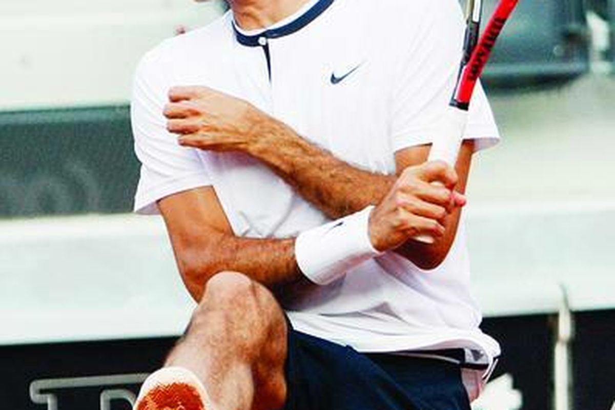 Petenis Swiss, Roger Federer, yang bermain ganda dengan Yves Allegro, meringis ketika bola pengembalian lawan, Johan Brunstrom dan Jean-Julien Rojer, menerpa pahanya dalam pertandingan Roma Master di Roma, Italia, Senin (26/4).
