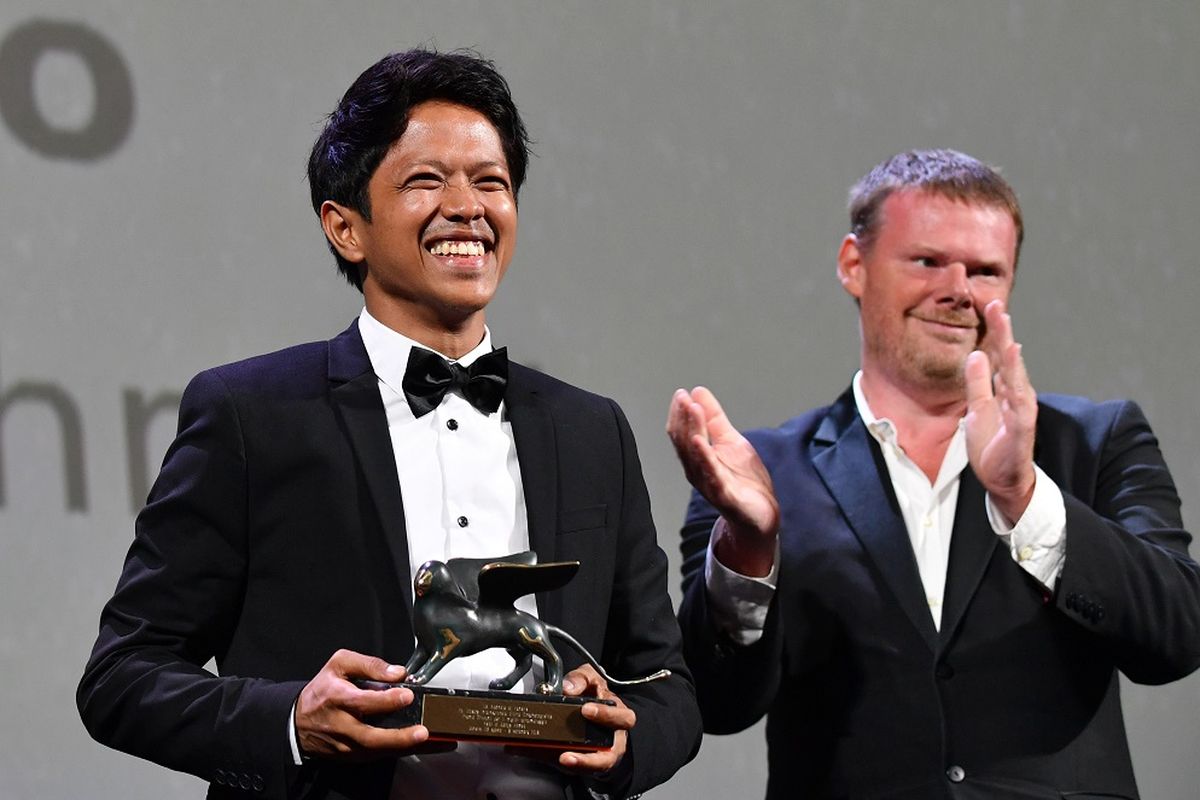 Sutradara asal Indonesia Aditya Ahmad (kiri) menggenggam trofi Best Short Film untuk film Kado dalam malam penghargaan Festival Film Venice yang digelar di Venice Lido, Italia, Sabtu (8/9/2018).