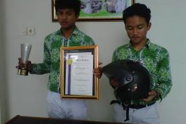 Naufal Rasendriya Apta dan Archel Valiano saat menunjukan piala kategori 6 thn National Young Investor Award 2013 dan helm berlampu sein ciptaanya 