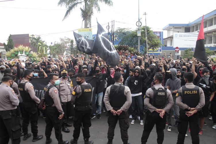 Kelompok massa beratribut serba hitam pada aksi demonstrasi menolak Omnibus Law dihadang polisi saat menuju Gedung DPRD di persimpangan Dago Jalan RE Martadinata, Sukabumi, Jawa Barat, Rabu (7/10/2020).