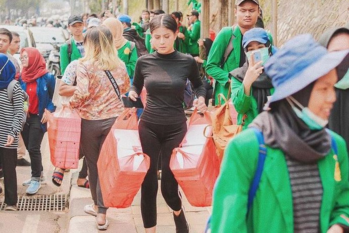 Selebgram Karin Novilda atau Awkarin saat membagi-bagikan 3.000 nasi kotak kepada mahasiswa yang melakukan aksi unjuk rasa di depan Gedung DPR, Jakarta Pusat, Selasa (24/9/2019). 