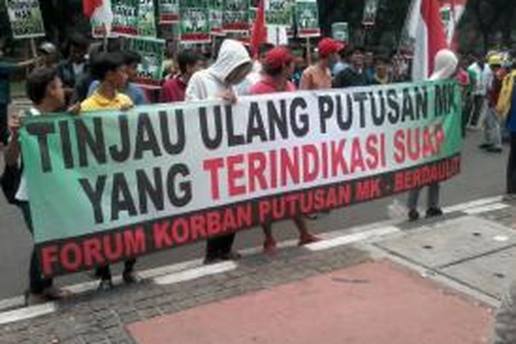 Ratusan orang melakukan aksi demo di depan Gedung Mahkamah Konstitusi (MK), Jalan Medan Merdeka Barat, Jakarta, Kamis (24/10/2013). Mereka yang menamakan diri sebagai Forum Korban Putusan MK Berdaulat menuntut agar MK segera meninjau kembali putusannya menyusul kasus dugaan suap yang menjerat Ketua MK nonaktif Akil Mochtar.