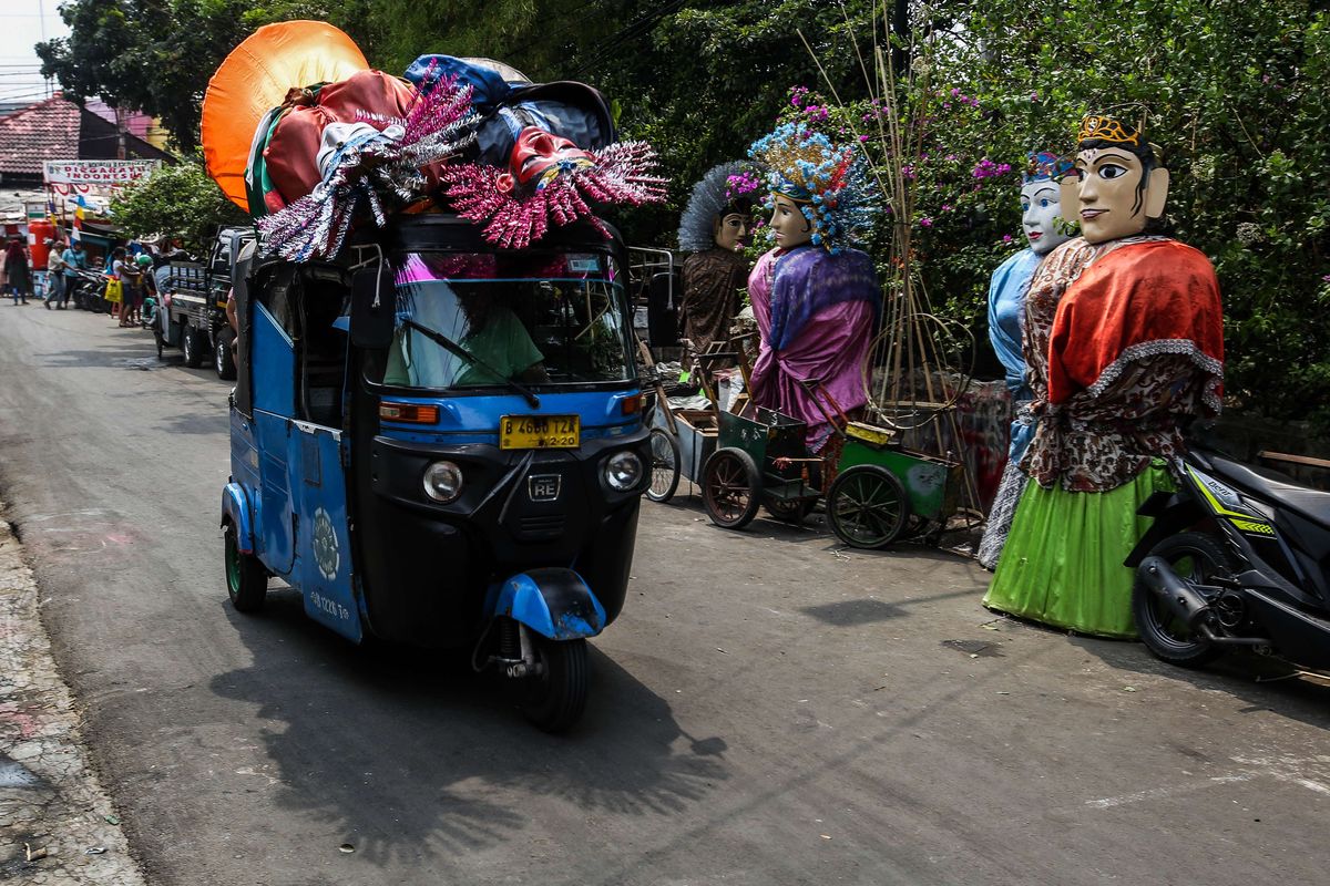 Bajaj yang membawa ondel-ondel melintas di Jalan Kembang Pacar, Senen, Jakarta Pusat, Rabu (2/9/2020). Pandemi Covid-19 dianggap menjadi tantangan terberat bagi para pengrajin ondel-ondel di Kramat Pulo setelah bertahan hidup di ibukota lebih dari lima dekade.