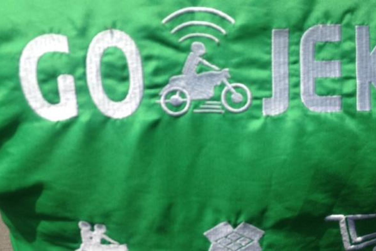 Logo Go-Jek di jaket salah satu driver atau pengendara.