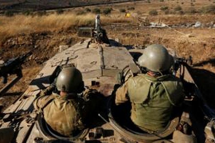 Prajurit AD Israel bersiaga di atas tank mereka sambil mengawasi pintu perbatasan Quneitra di dataran tinggi Golan.