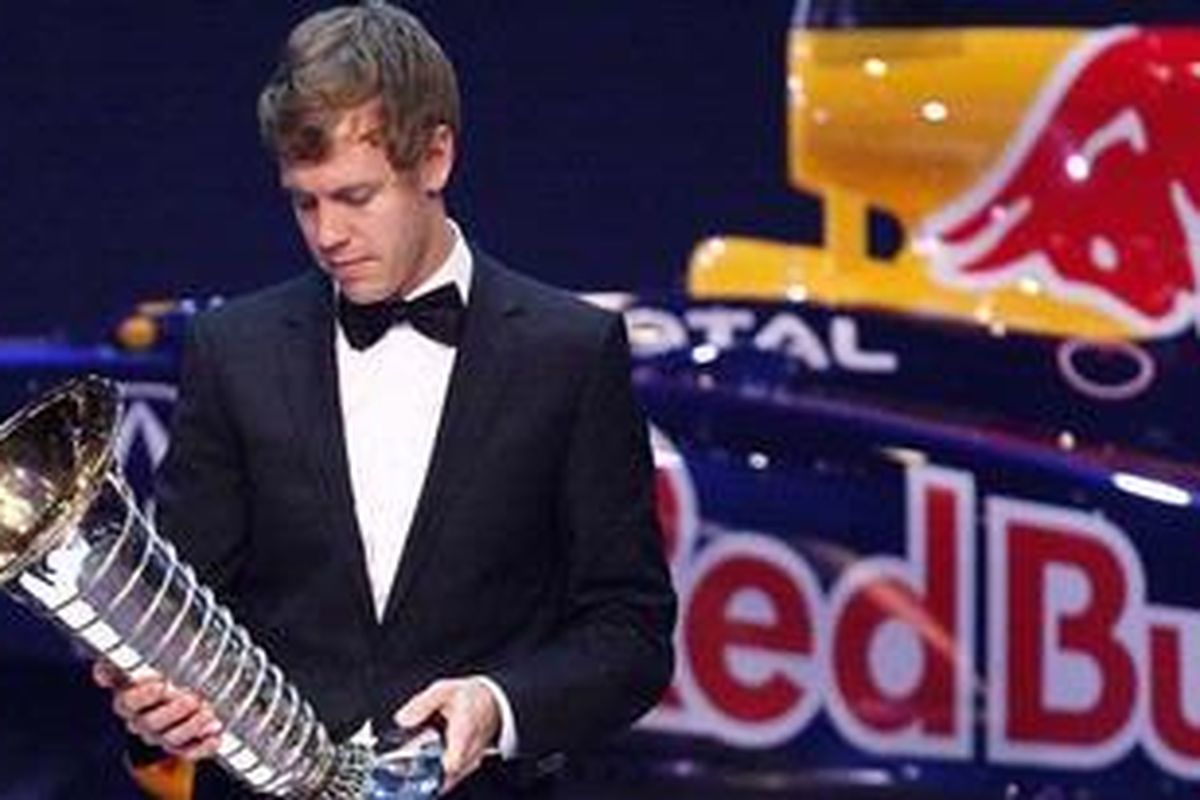 Pebalap Red Bull Racing, Sebastian Vettel, ketika menerima trofi juara dunia F1 musim 2011.