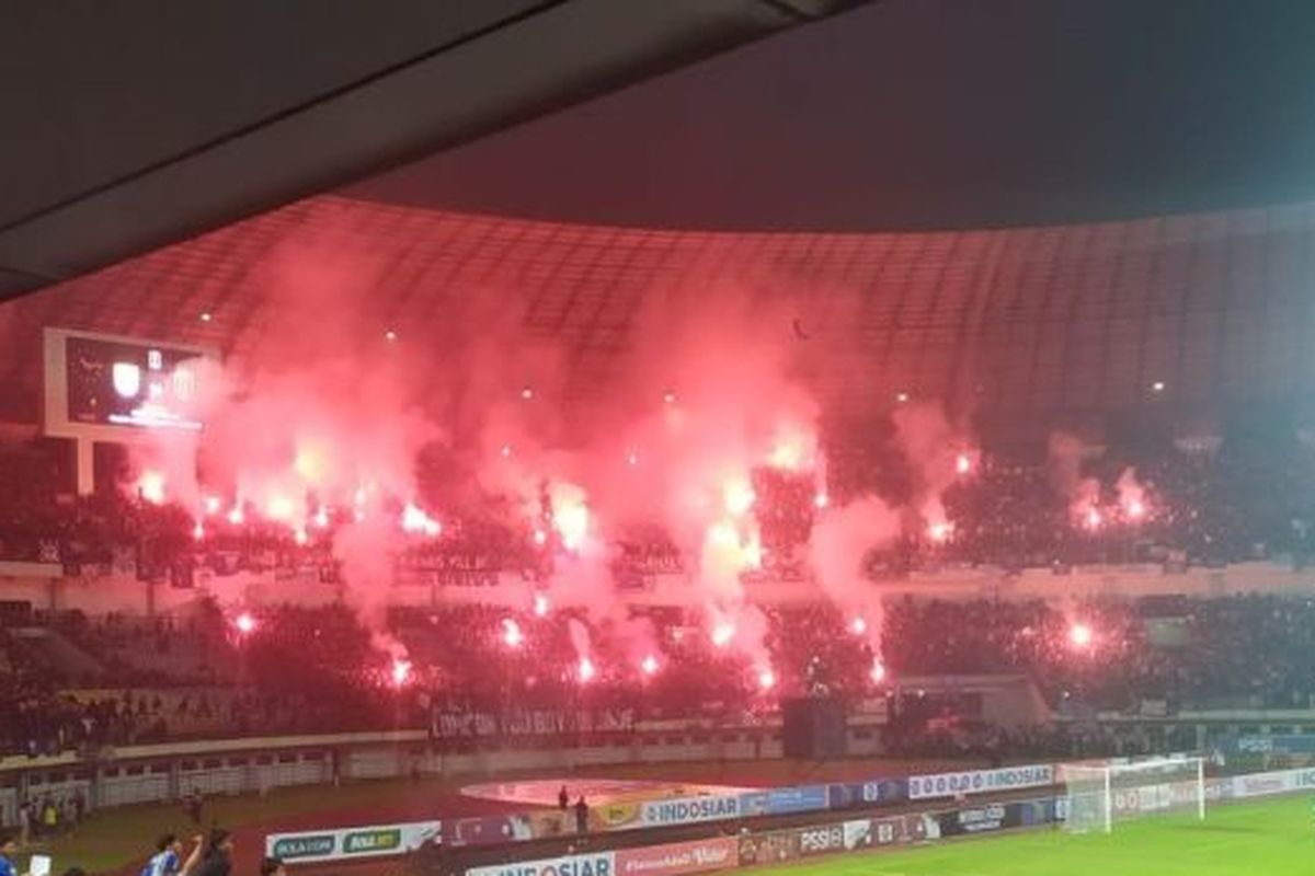 Sejumlah oknum bobotoh menyalakan flare atau suar di tribun utara Stadion Gelora Bandung Lautan Api (GBLA) Kota Bandung, Jawa Barat, Minggu (12/6/2022).  