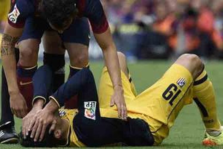 Striker Atletico Madrid, Diego da Silva Costa (terbaring) mengalami cedera dalam laga melawan Barcelona di Camp Nou, Sabtu (17/5/2014). Costa alami cedera hamstring.