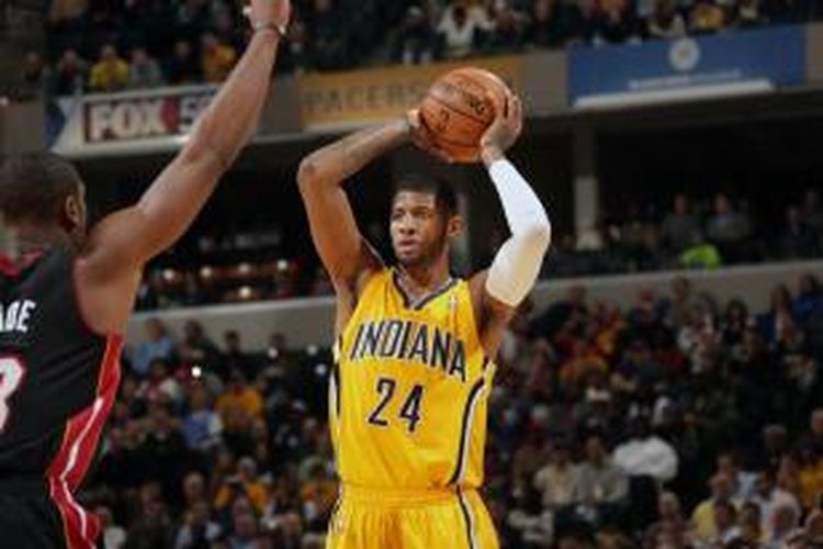 Pebasket Indiana Pacers, Paul George (24) bersiap melempar bola di depan pamain Miami Heat, Dwyane Wade, pada pertandingan lanjutan kompetisi NBA, di Bankers Life Fieldhouse, Selasa (10/12/2013).