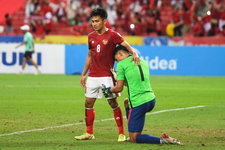 Pemain Indonesia Witan Sulaeman (kiri) menguatkan pemain Singapura Ikhsan Fandi usai pertandingan leg kedua semifinal Piala AFF 2020 antara Singapura vs Indonesia di National Stadium, Singapura, Sabtu (25/12/2021). Timnas Indonesia dipastikan melaju ke final Piala AFF 2020 setelah menumbangkan Singapura 4-2 pada laga semifinal kedua.