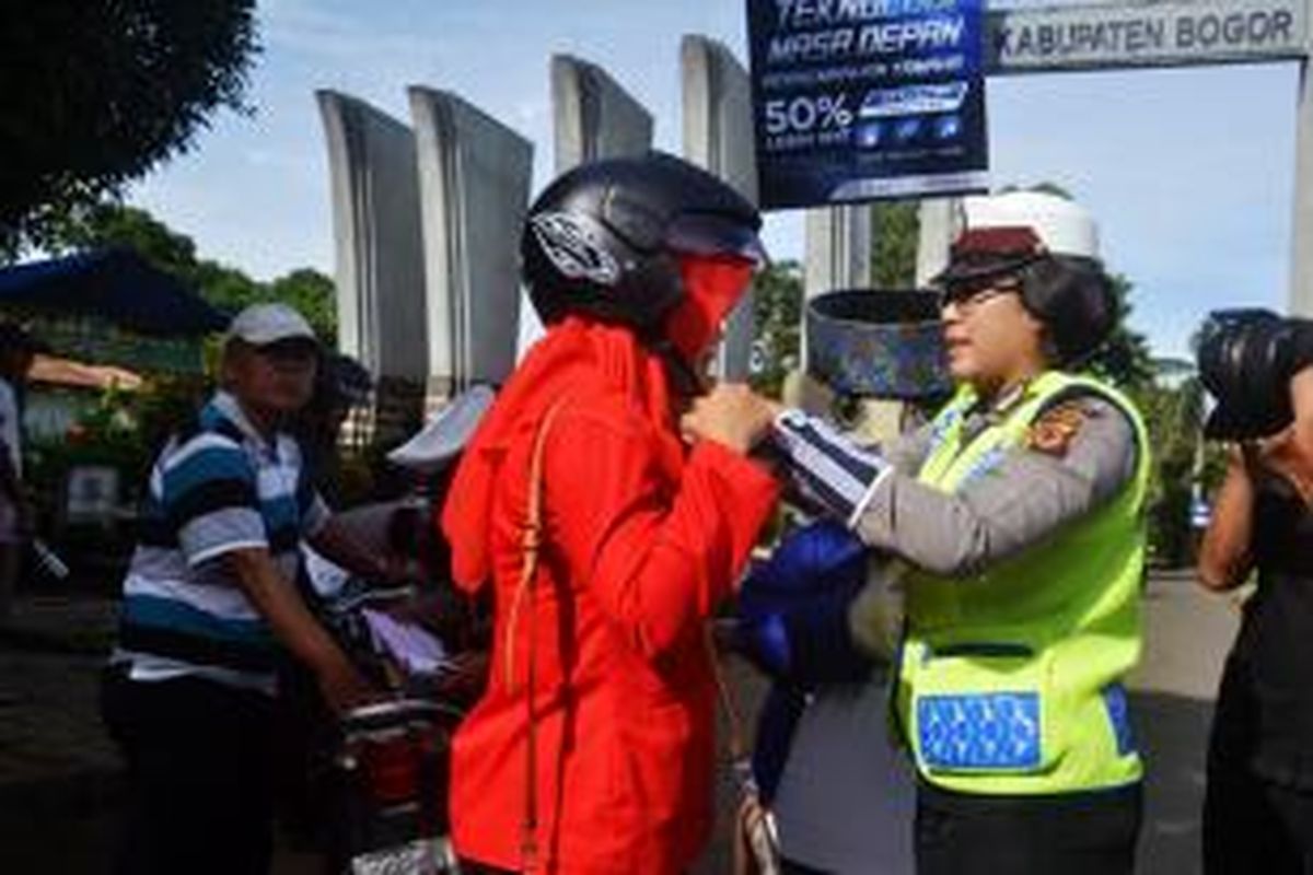 Puluhan helm dibagikan secara cuma-cuma alias gratis kepada pengendara sepeda motor yang melintas di Jalan Raya Tegar Beriman, Cibinong, Kabupaten Bogor, Senin (8/12/2014). 