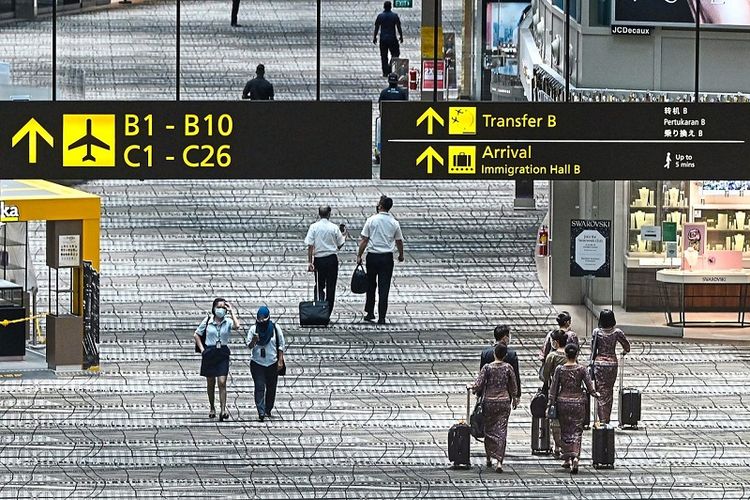 Awak pesawat berjalan di aula transit Bandara Internasional Changi, Singapura.