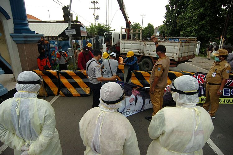 Petugas memasang beton saat isolasi wilayah Kota Tegal, Jawa Tengah, Minggu (29/3/2020). Isolasi wilayah dilakukan dengan menutup sebanyak 50 titik jalan masuk ke Kota Tegal dan hanya dibuka satu jalan yaitu jalan Proklamasi dengan pemeriksaan oleh Dinas Kesehatan sebelum memasuki wilayah kota tersebut untuk antisipasi penyebaran COVID-19.