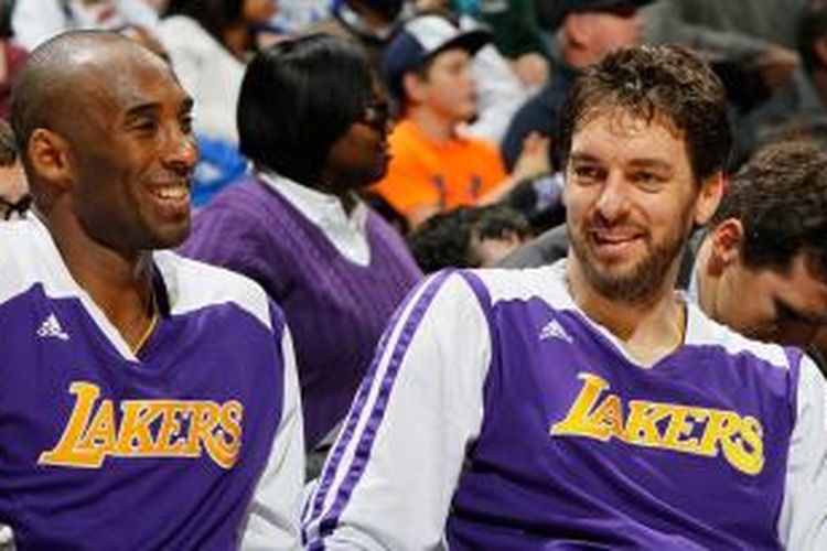 Pebasket Los Angeles Lakers, Kobe Bryant (kiri) dan Pau Gasol bercanda saat duduk di bench pada laga melawan Atlanta Hawks di Philips Arena, Senin (16/12/2013).