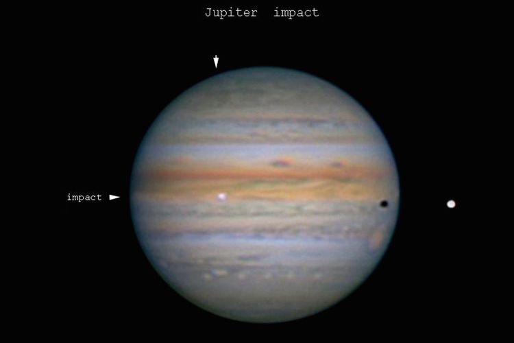 Salah satu citra terjadinya tumbukan benda langit di Jupiter pada 14 September 2021 fajar waktu Indonesia. Kilatan cahaya tumbukan ditandai dengan titik potong kedua panah putih. Bintik hitam di sisi kanan merupakan bayangan Io, salah satu satelit alamiah utama Jupiter. Citra dihasilkan melalui teleskop Newtonian 408 mm oleh Harold Palaske, astronom amatir dari Langendorf (Jerman).