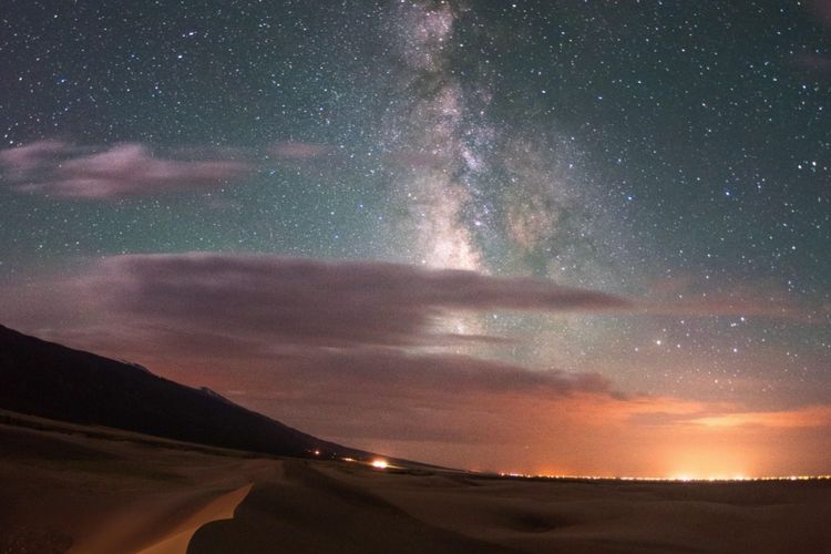Senjakala berbalut taburan bintang di Taman Nasional Great Sand Dunes, Colorado.
