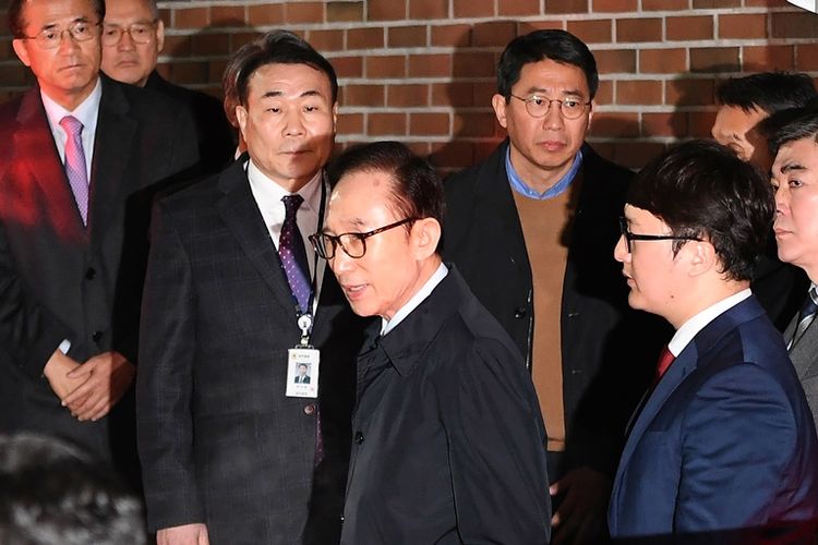 Mantan presiden Korea Selatan Lee Myung-bak meninggalkan rumahnya dam dipindahkan ke pusat penahanan di Seoul, Jumat (23/3/2018) tengah malam. (AFP/Jung Yeon-Je)
