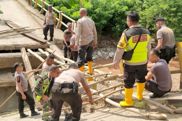 Aparat TNI dan Polri membangun jembatan darurat di Desa Oelatimo Kecamatan Kupang Timur, Kabupaten Kupang, Nusa Tenggara Timur (NTT), menggunakan kayu, Senin (2/1/2023)