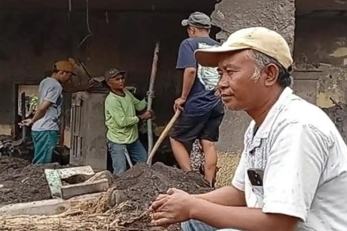  Toha, warga Dusun Sumbersari, Desa Supiturang, Kecamatan Pronojiwo, Kabupaten Lumajang tampak termenung menetap reruntuhan rumahnya setelah erupsi Semeru membuatnya kehilangan uang Rp 10 juta, Minggu (23/11/2025)(Surya/Erwin Wicaksono)