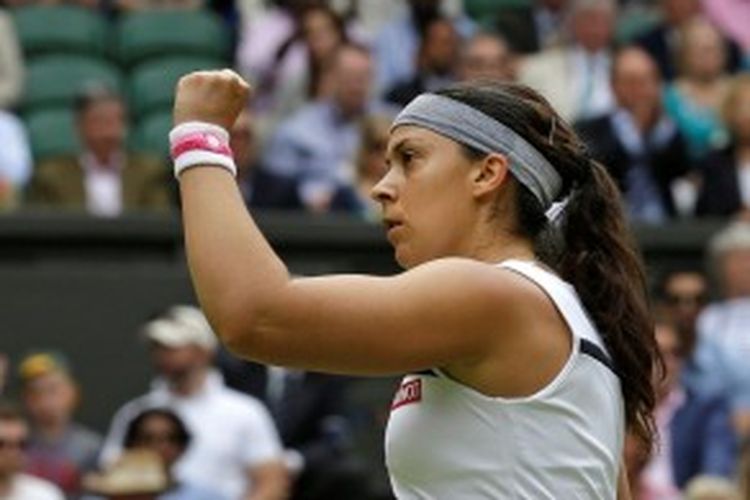 Petenis Perancis, Marion Bartoli, mengepalkan tangan setelah memenangi set pertama atas Kirsten Flipkens dari Belgia, saat saling berhadapan di semifinal turnamen Grand Slam Wimbledon, Kamis (4/7/2013).