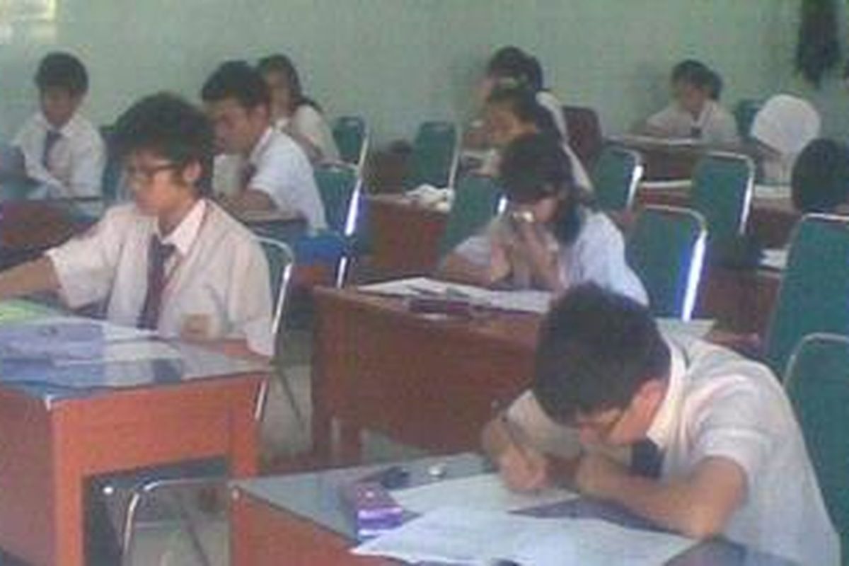 Siswa mengerjakan naskah ujian nasional (UN) di SMPN 1, Kota Kediri, Jawa Timur, Senin (23/4/2012).