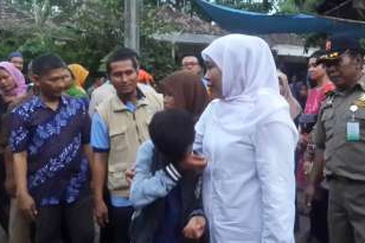 Menteri Sosial RI Khofifah Indar Parawansa (pakaian putih) mendekap Sa'adah (kerudung coklat) dan anaknya Sofyan yang menangis usai mendapat bantuan RS-RTLH sebesar Rp 15 juta untuk membangun rumah baru, Minggu (1/5/2016)