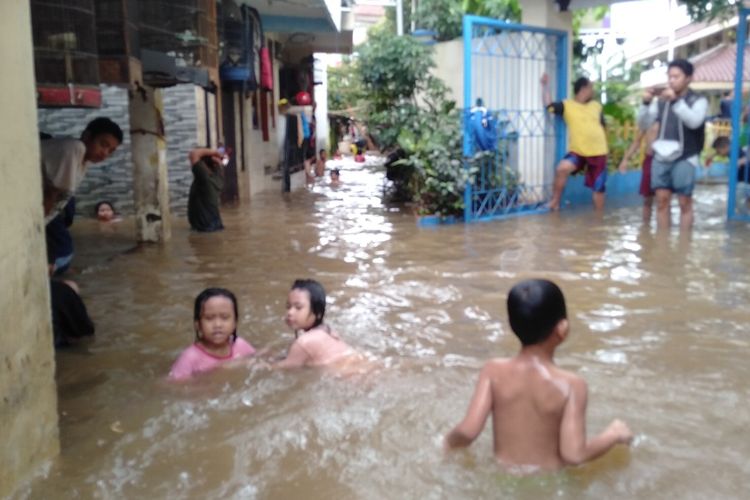 Anak anak bermain di air banjir di permukiman warga di Jalan Kemang Timur XI, Bangka, Mampang Prapatan, Jakarta Selatan,  Selasa (25/2/2020)