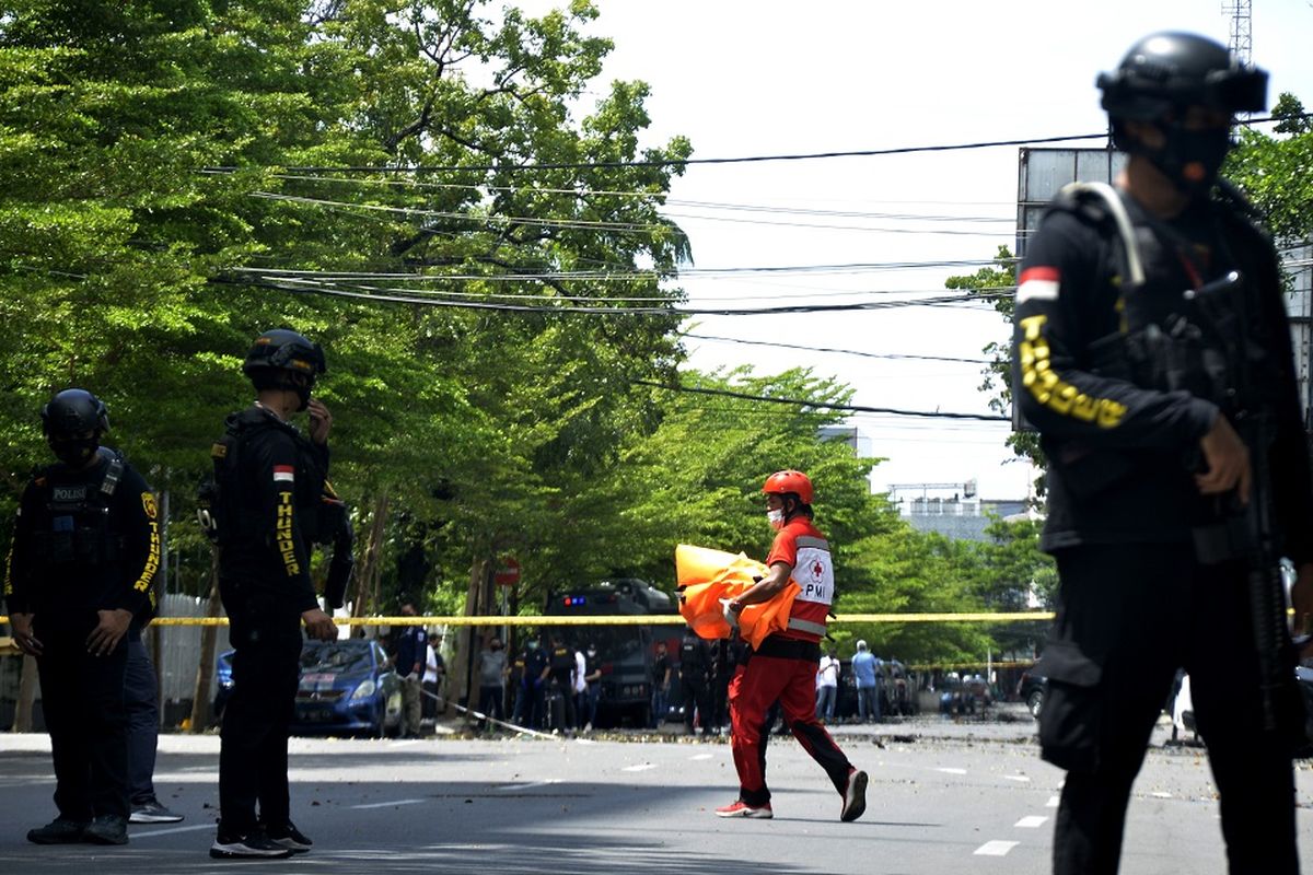 Petugas kepolisian melakukan pemeriksaan di sekitar sisa-sisa ledakan dugaan bom bunuh diri di depan Gereja Katolik Katedral, Makassar, Sulawesi Selatan, Minggu (28/3/2021). Ledakan bom di gereja tersebut mengakibatkan dua korban tewas yang diduga pelaku bom bunuh diri serta melukai 14 orang jemaat dan petugas gereja. ANTARA FOTO/Abriawan Abhe/foc.