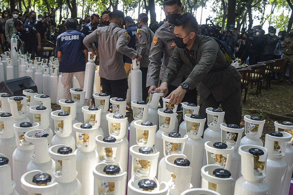 Sejumlah anggota Polisi menata sejumlah tabung oksigen saat penyerahan barang bukti tabung oksigen hasil pengungkapan kasus tindak kejahatan di Jakarta, Selasa (27/7/2021). Sebanyak 138 tabung yang sudah dilakukan pemeriksaan oleh Kementerian Kesehatan tersebut diserahkan kepada Pemerintah Provinsi DKI Jakarta untuk digunakan sebagai penanggulangan Covid-19 di sejumlah fasilitas pelayanan kesehatan di Jakarta.