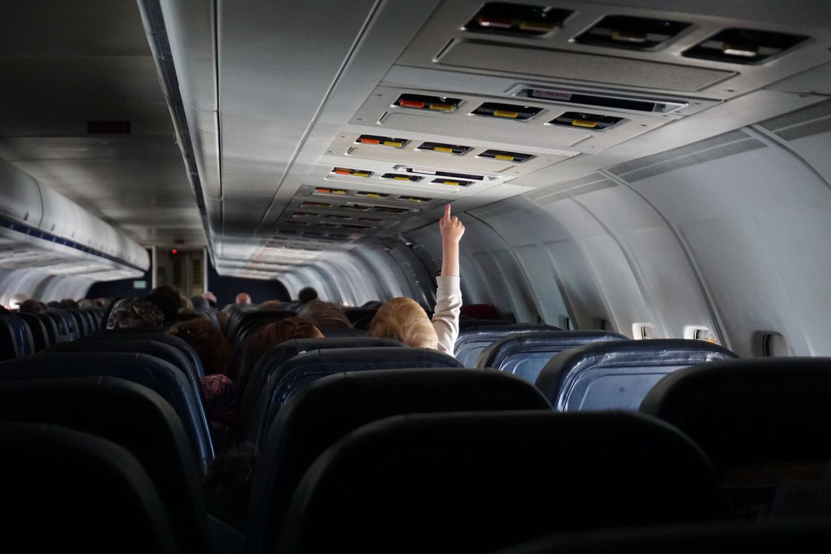 Ilustrasi kabin pesawat dengan lampu yang dimatikan.