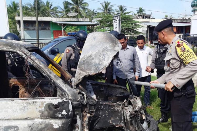 Polisi melihat mobil milik pencuri yang dibakar warga di Desa Matang Puntong, Kecamatan Seunuddon, Kabupaten Aceh Utara, Selasa (22/1/2019) 